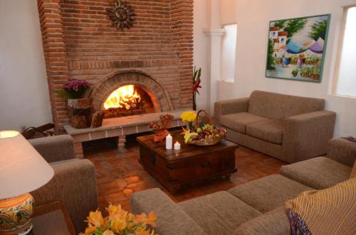a living room with a fireplace with couches and a table at Villas Danza del Sol in Ajijic