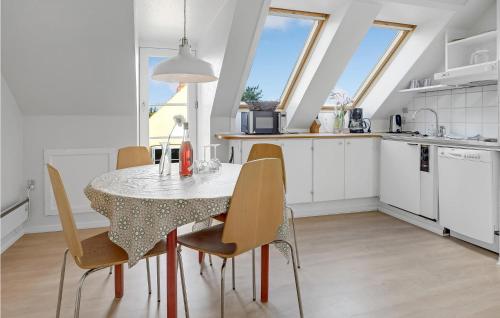 a kitchen and dining room with a table and chairs at Nice Apartment In Svaneke With Wifi in Svaneke