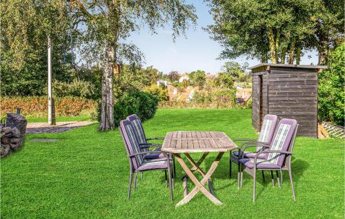 a wooden table and chairs in the grass at Nice Apartment In Svaneke With Wifi in Svaneke