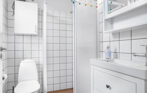 a white bathroom with a toilet and a sink at Amazing Apartment In Gudhjem With 2 Bedrooms, Wifi And Outdoor Swimming Pool in Gudhjem