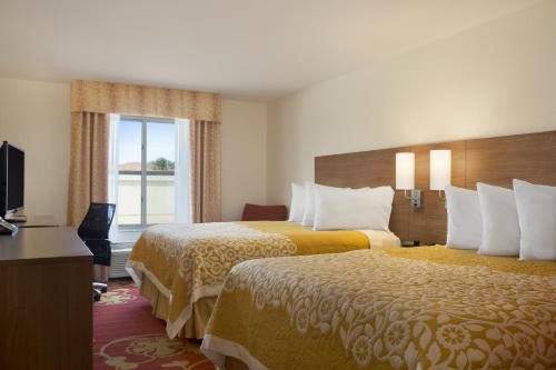 Säng eller sängar i ett rum på Days Inn & Suites by Wyndham Belmont