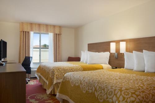 Ένα ή περισσότερα κρεβάτια σε δωμάτιο στο Days Inn & Suites by Wyndham Belmont