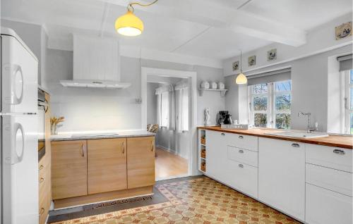 a kitchen with white cabinets and wooden counter tops at Amazing Home In Højer With Wifi in Højer