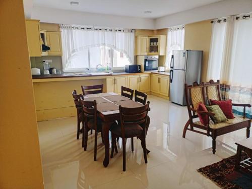 a kitchen with a table and chairs and a refrigerator at Royal Residency in Kandy