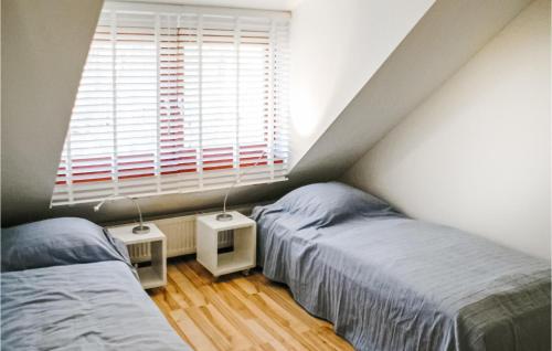 2 camas individuales en una habitación con ventana en 2 Bedroom Lovely Home In Rekem-lanaken en Bovenwezet