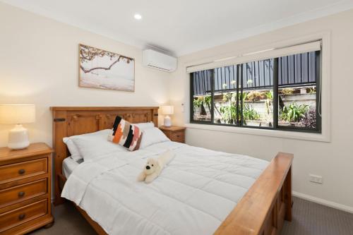 une chambre avec un lit blanc avec un chien dessus dans l'établissement Trumpeter, à Corlette