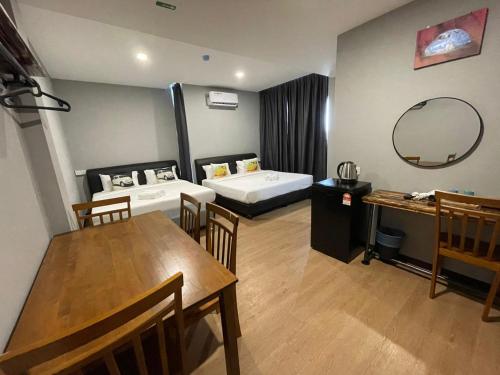 una camera d'albergo con letto, tavolo e sedie di RNK BoutiQue HOTEL a Jitra