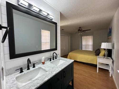 a bathroom with two sinks and a bedroom with a bed at Beautiful House Sleeps 12 - Hot Tub - Walk to Beach in Panama City Beach