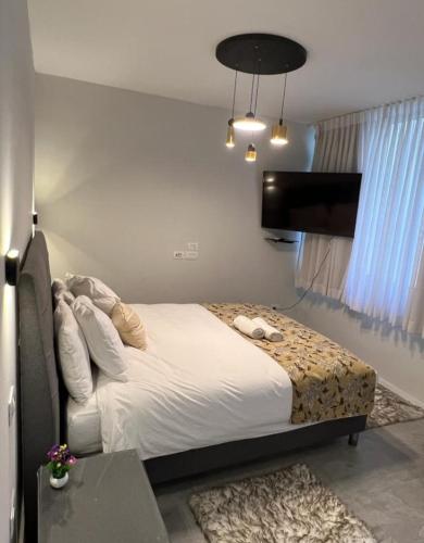 a bedroom with a bed and a flat screen tv at sea view apartment in Bat Yam
