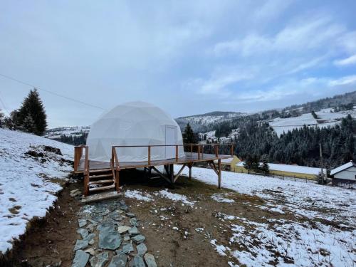 a large dome tent sitting on top of a snow covered hill at WildGlampingArieseni in Arieşeni