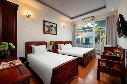 Habitación de hotel con 2 camas y ventana en Hanoi Moonlight Hotel, en Hanói