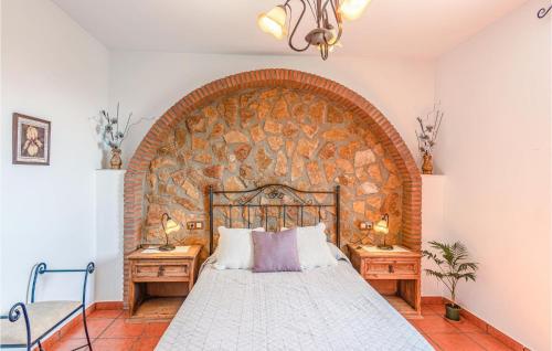 a bedroom with a brick wall with a bed and two night stands at Lovely Home In Mecina Bombarón in Mecina Bombarón