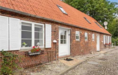 a brick building with an orange roof and white doors at 2 Bedroom Cozy Home In Tønder in Tønder