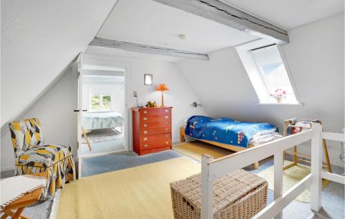 トゥナーにあるNice Home In Tnder With Wifiのベッドと椅子付きの小さな屋根裏部屋です。
