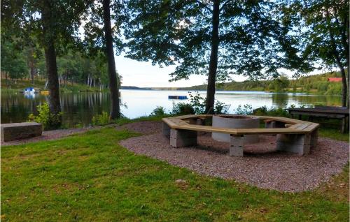 un banco sentado en el césped junto a un lago en Gorgeous Home In Degerfors With Kitchen, en Degerfors