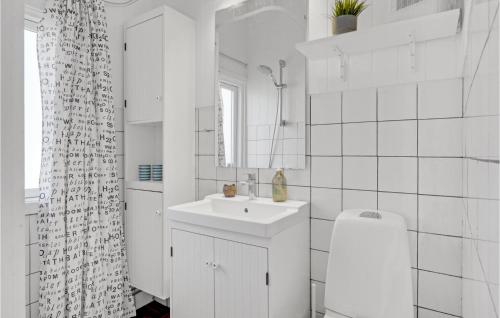 Baño blanco con lavabo y espejo en 4 Bedroom Cozy Home In Nykbing Sj en Ebbeløkke