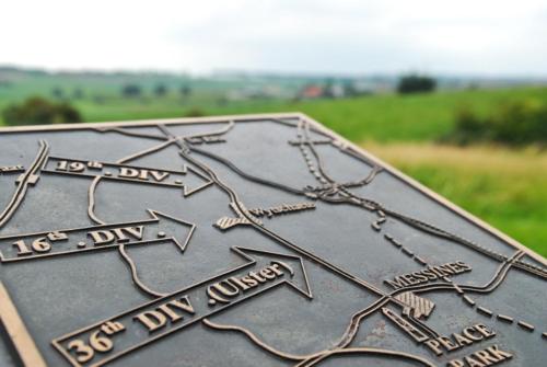 a metal sign with arrows on top of a plate at Skyline in Ypres