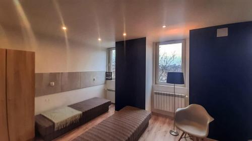 Pokój z 2 łóżkami, krzesłem i oknem w obiekcie MDA Katowice Apartments w mieście Katowice