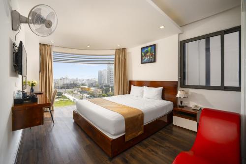 a hotel room with a bed and a red chair at Waikiki Beach Hotel Da Nang in Da Nang