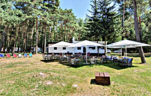 a group of tables and chairs with umbrellas at Cozy Home In Sulnowo With Sauna in Sulnówko