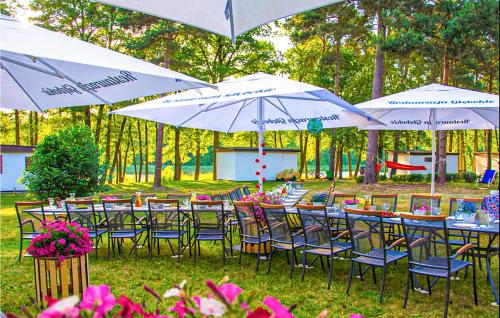 a group of tables and chairs with umbrellas at Cozy Home In Sulnowo With Sauna in Sulnówko