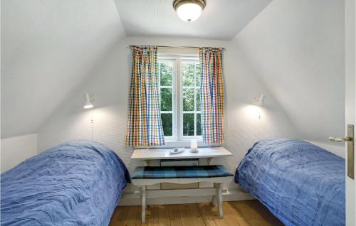 um quarto com 2 camas e uma janela em 2 Bedroom Cozy Home In Gudhjem em Gudhjem