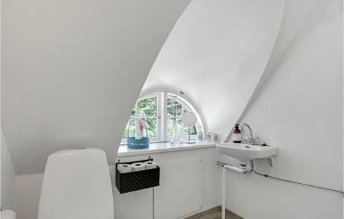 uma casa de banho branca com um lavatório e uma janela em 2 Bedroom Cozy Home In Gudhjem em Gudhjem