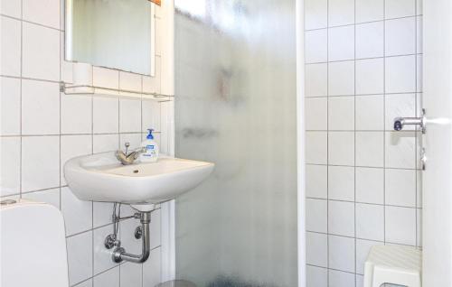 Baño blanco con lavabo y espejo en Nice Home In Allinge With Wifi en Allinge