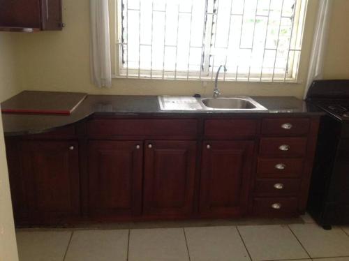 a kitchen with a sink and a window at Hibiscus Cottage in Belle Air Summit