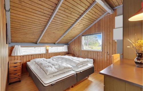 a bedroom with a bed in a wooden room at Stunning Home In Rm With Kitchen in Bolilmark