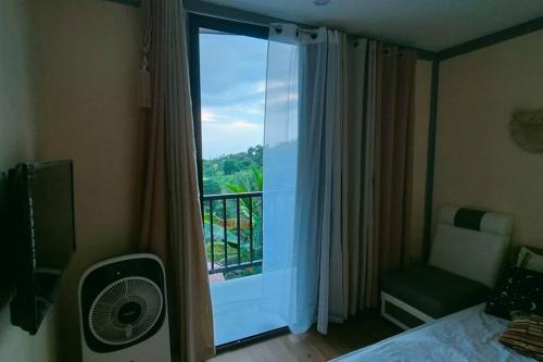 a bedroom with a window with a view of a balcony at a CABIN MOUNTAIN PEAK in Sampalok