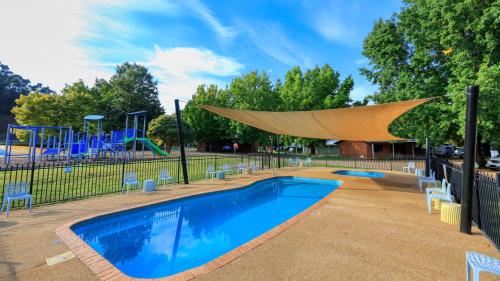 a swimming pool with a slide and a playground at Bright Valley Holiday Park in Bright