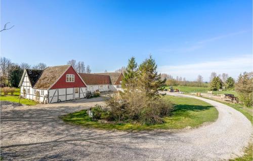 una fattoria con un fienile rosso e una strada tortuosa di Stunning Apartment In Nørre Alslev a Nørre Alslev