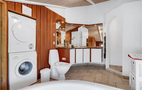 a bathroom with a washer and dryer in it at Nice Home In Grenaa With Sauna in Grenå
