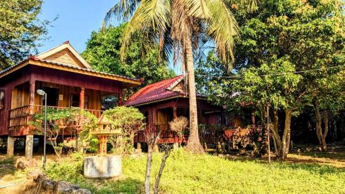 a house with a palm tree in front of it at Sok Mean Bungalows in Koh Rong Sanloem