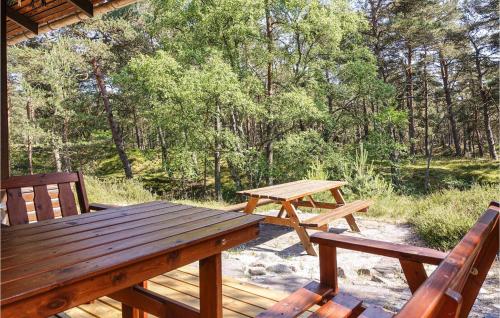 ein Picknicktisch und zwei Stühle auf der Veranda einer Hütte in der Unterkunft 3 Bedroom Beautiful Home In Nexø in Neksø