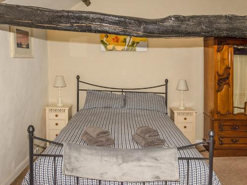 シャップにあるPrimrose Cottageのベッドルーム1室(ベッド1台、ナイトスタンド2台、ランプ2つ付)