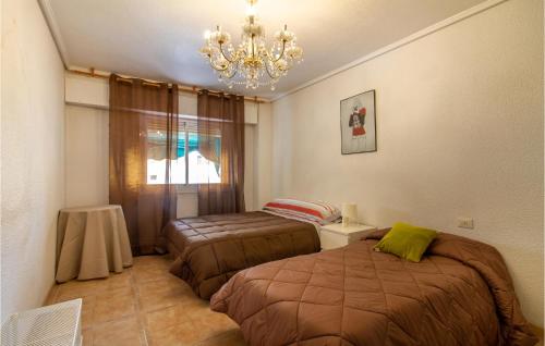 サンタ・ポラにあるStunning Apartment In Santa Pola With 3 Bedroomsのベッドルーム1室(ベッド2台、シャンデリア付)