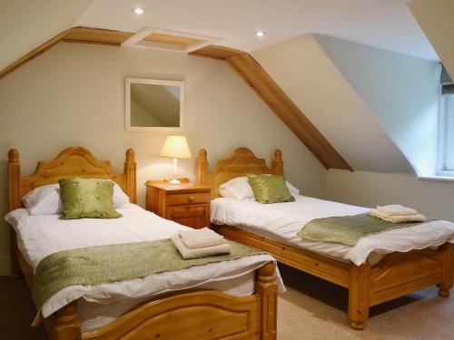 Mercy Cottage - Beaufort Estate في Belladrum: سريرين توأم في غرفة مع علية