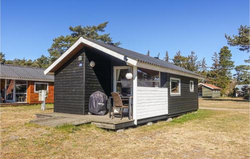 a black and white tiny house with a chair in it at Cozy Home In Nexø With Wifi in Neksø