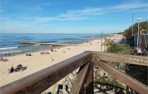 a beach with people on the sand and the ocean at 1 Bedroom Stunning Apartment In Mielno in Mielno