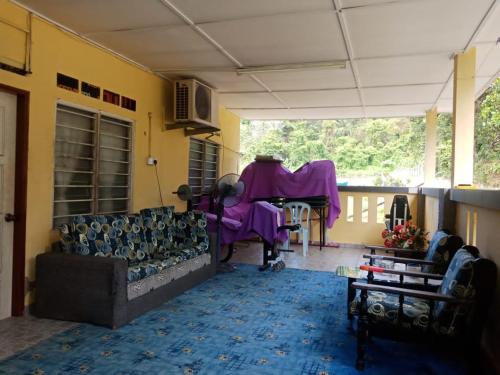 un soggiorno con divano e tavolo di Kuntum Cottage Bad & Breakfast a Kampong Tanjong Ipoh