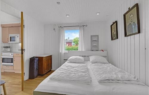 Awesome Home In Ebberup With Wifi في Ebberup: غرفة نوم بيضاء مع سرير كبير ونافذة
