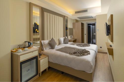 Asilzade Hotel Sirkeci في إسطنبول: غرفه فندقيه سرير وتلفزيون
