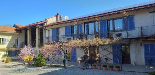 a house with blue shutters on the side of it at Agriturismo Cascina Knec in Feisoglio
