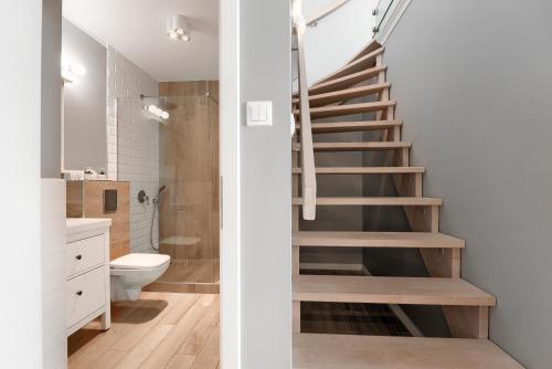シュチェチンにあるEXCLUSIVE New Town Apartmentsのバスルーム(階段付)、トイレが備わります。