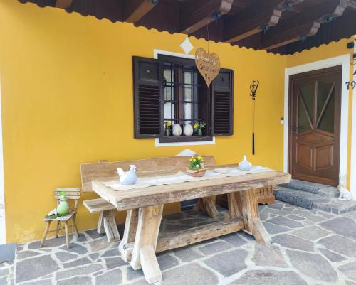 una mesa de madera frente a una pared amarilla en Die Hube en Leutschach