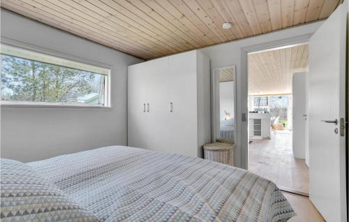 een slaapkamer met een bed en een groot raam bij Awesome Home In Thyholm With Kitchen in Thyholm