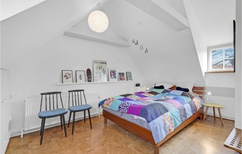 Beautiful Home In Ribe With Wifi في ريبي: غرفة نوم فيها سرير وكرسيين