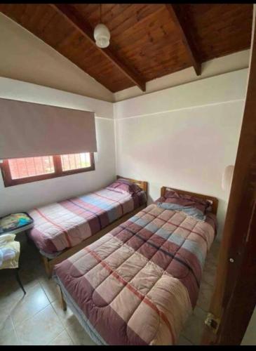 a bedroom with two beds and a window at Cabaña a pasos del Faro De La Serena in La Serena